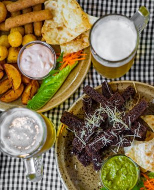 barda masada bira bardağı sarımsak ve diğer atıştırmalık ile ekmek kruton