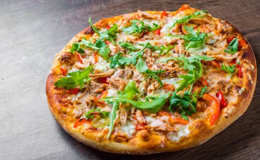 Mozzarella peynirli pizza, somon balığı, domates sosu, biber. Ahşap masa arka planda İtalyan pizza