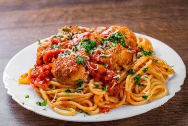 koyu ahşap arka plan üzerinde bir tabakta domates soslu köfte makarna spagetti