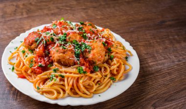 koyu ahşap arka plan üzerinde bir tabakta domates soslu köfte makarna spagetti