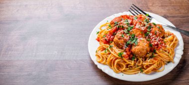 koyu ahşap arka plan üzerinde bir tabakta domates soslu köfte makarna spagetti