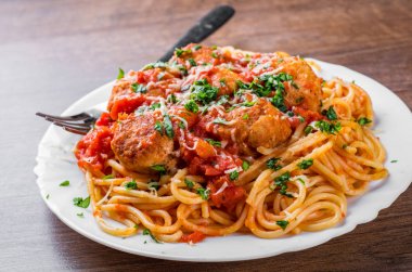 koyu ahşap arka plan üzerinde bir tabakta domates soslu köfte makarna spagetti