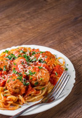 koyu ahşap arka plan üzerinde bir tabakta domates soslu köfte makarna spagetti