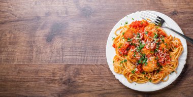 koyu ahşap arka plan üzerinde bir tabakta domates soslu köfte makarna spagetti