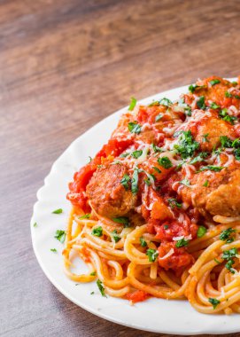 koyu ahşap arka plan üzerinde bir tabakta domates soslu köfte makarna spagetti