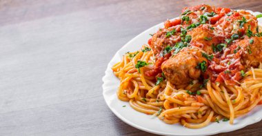 koyu ahşap arka plan üzerinde bir tabakta domates soslu köfte makarna spagetti