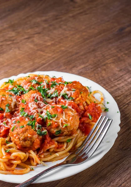 koyu ahşap arka plan üzerinde bir tabakta domates soslu köfte makarna spagetti