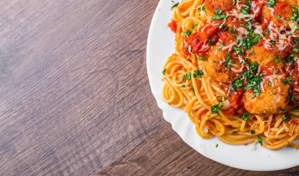 koyu ahşap arka plan üzerinde bir tabakta domates soslu köfte makarna spagetti