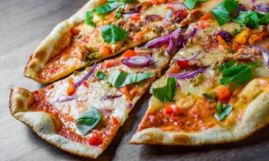 Mozzarella peyniri, soğan, ton balığı, domates sosu, biber, fesleğen ile pizza. Ahşap masada İtalyan Pizza