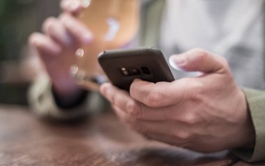 Erkek eli kamerayı kapat, akıllı telefonu tut, bira iç ve barda veya barda mesaj oku.
