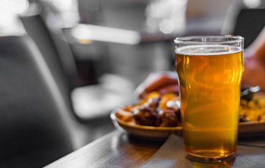 bar veya pub ahşap masa arka plan üzerinde aperatifler ile soğuk bira ve tabak cam