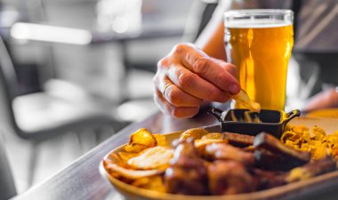 bar veya pub ahşap masa arka plan üzerinde aperatifler ile soğuk bira ve tabak cam ile adam el