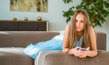 evde kanepede yatan uzun saçlı genç genç esmer kız portresi akıllı telefon kullanarak eğlenin