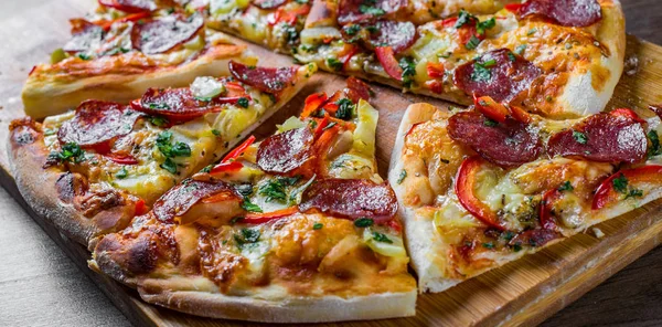 Mozzarella peynirli Pepperoni Pizza, salam, biber. Baharatlar ve taze fesleğen. Ahşap masa arka planda İtalyan pizza