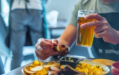 bar veya pub ahşap masa arka plan üzerinde aperatifler ile soğuk bira ve tabak cam ile adam el