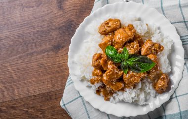 Ahşap bir masa arka plan üzerinde beyaz tabakta sos ve Pirinç ile Tavuk Göğsü