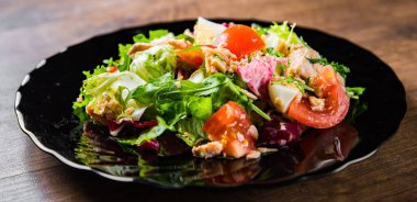 Balıklı taze salata, roka, yumurta, kırmızı biber, marul, taze salata yaprakları ve domates.