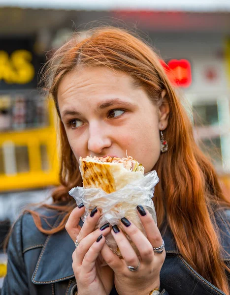 若いですティーンRedhead女の子とともに長いです髪食べる鶏Shawarma上の通り — ストック写真