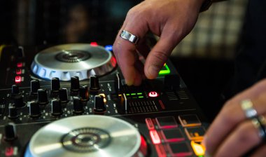 DJ Hands, DJ konsol karıştırıcısında gece kulübü sahnesinde müzik oluşturup düzenliyor.