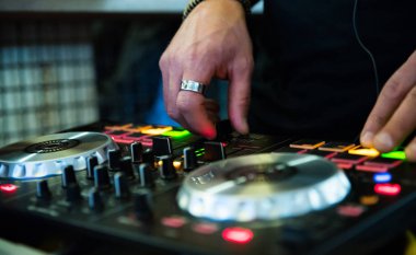 DJ Hands, DJ konsol karıştırıcısında gece kulübü sahnesinde müzik oluşturup düzenliyor.
