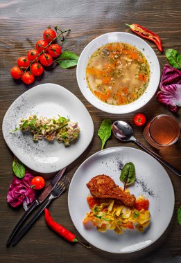 Masada üç çeşit yemek var. Çorba, salata ve sebzeli tavuk gibi üç öğünden oluşan lezzetli öğle yemeği seti.