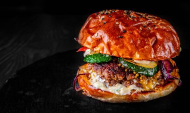 Esmer arka planda sebzeli geleneksel sığır burger.