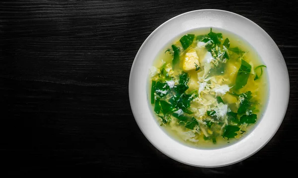 Green Sorrel soup in white plate on black wooden table background — Stock Image Green Sorrel Soup White Plate Black Wooden Table Background Royalty Free Stock Images