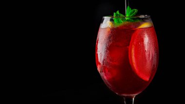 Şarap kadehinde soğuk sangria şarabı. Siyah arka planda yansıması var.