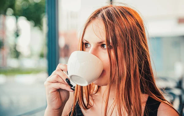 若いですティーンRedhead女の子とともに長い髪とともに熱いコーヒーのカップで街のストリートカフェテラス — ストック写真