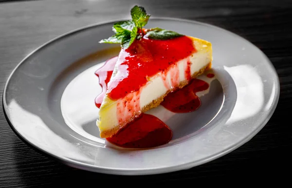 Φράουλα Cheesecake Σερβίρεται Λευκό Πιάτο Μαύρο Ξύλινο Τραπέζι Φόντο — Φωτογραφία Αρχείου