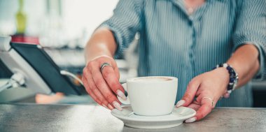 Barda ya da kafede elinde bir fincan aromatik latte ya da cappuccino kahvesi tutan kadın kahveciler.