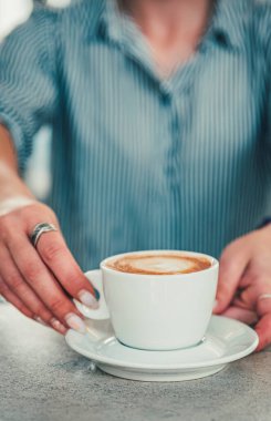 Barda ya da kafede elinde bir fincan aromatik latte ya da cappuccino kahvesi tutan kadın kahveciler.