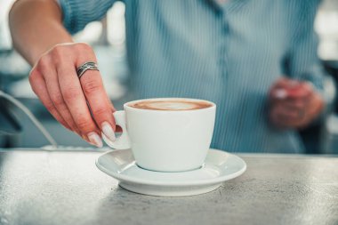 Barda ya da kafede elinde bir fincan aromatik latte ya da cappuccino kahvesi tutan kadın kahveciler.
