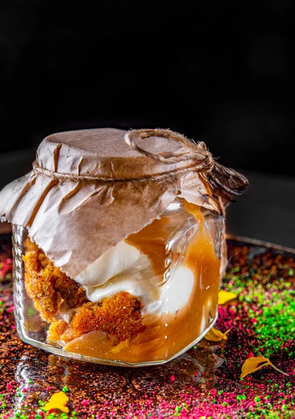 carrot cake in a glass jar on a black background