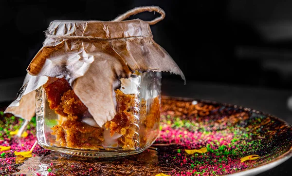 carrot cake in a glass jar on a black background