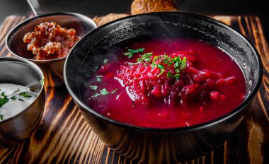 Pancar çorbası. Geleneksel Ukrayna ya da Rus çorbası. Ahşap masada bir kasede ekşi krema.