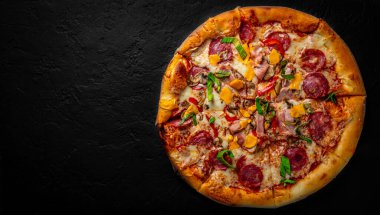 Mozzarella peynirli pizza, salam, tavuk eti, sığır eti, jambon, domates sosu, biber, baharat. Koyu gri arka planda İtalyan pizzası