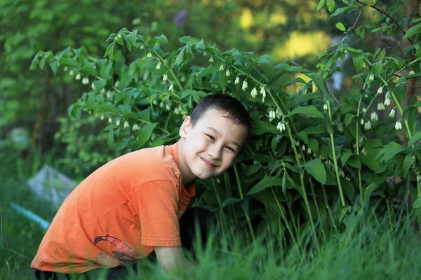 Chlapec s květinami venku — Stock fotografie