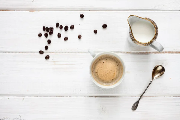 Tasse Kaffee Sahne Und Kaffeebohnen Auf Einem Weißen Holztisch — Stockfoto