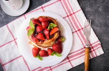 Lezzetli Amerikan krep ile taze çilek, reçel ve yaprakları nane. Bir beyaz tabakta. Sağlıklı kahvaltı. Üstten görünüm, yukarıdan görünüm