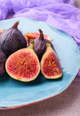 Taze incir. Bütün incir ve mavi seramik plaka üzerinde içinde dilimlenmiş yarım incir