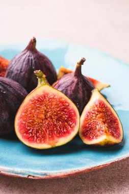 Taze incir. Bütün incir ve mavi seramik plaka üzerinde içinde dilimlenmiş yarım incir