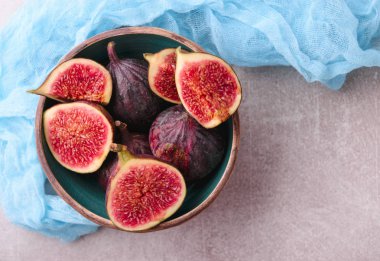 Taze incir. Bütün incir ve seramik kase dilimlenmiş içinde yarım incir. En iyi görünümü yukarıdaki. Mavi tül kumaş ile.