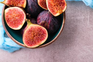 Taze incir. Bütün incir ve seramik kase dilimlenmiş içinde yarım incir. En iyi görünümü yukarıdaki. Mavi tül kumaş ile.