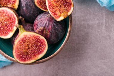 Taze incir. Bütün incir ve seramik kase dilimlenmiş içinde yarım incir. En iyi görünümü yukarıdaki. Mavi tül kumaş ile.