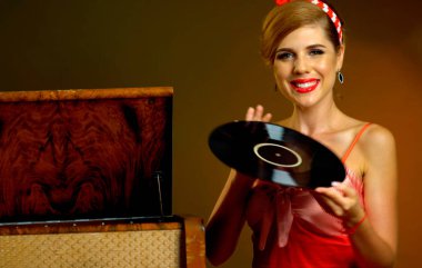 Retro kadın müzik vinil kaydı ile. Kırmızı elbise giyen kız pin-up stil.