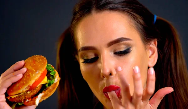 Mujer comiendo hamburguesa. Chica quiere comer comida rápida . — Foto de Stock