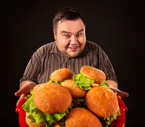 デブ男を食べるファーストフードのハンバーグ。太り過ぎの人の朝食. — ストック写真
