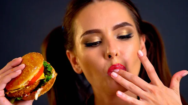 Mujer comiendo hamburguesa. Chica quiere comer comida rápida . — Foto de Stock