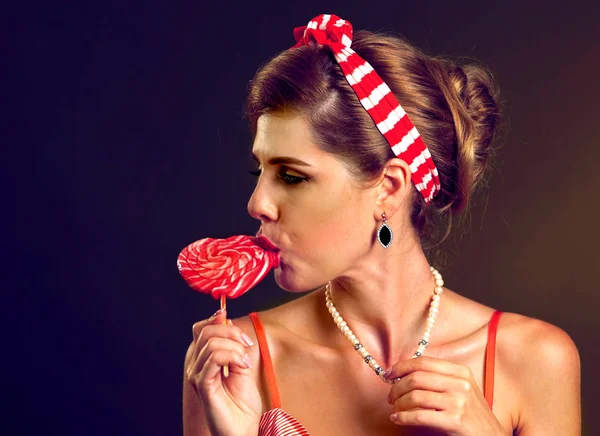 Woman eating lollipops. Girl in pin-up style hold striped candy. — Stock Photo, Image